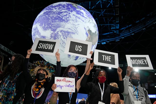 <p>Climate protesters hold up signs at the UN </p>