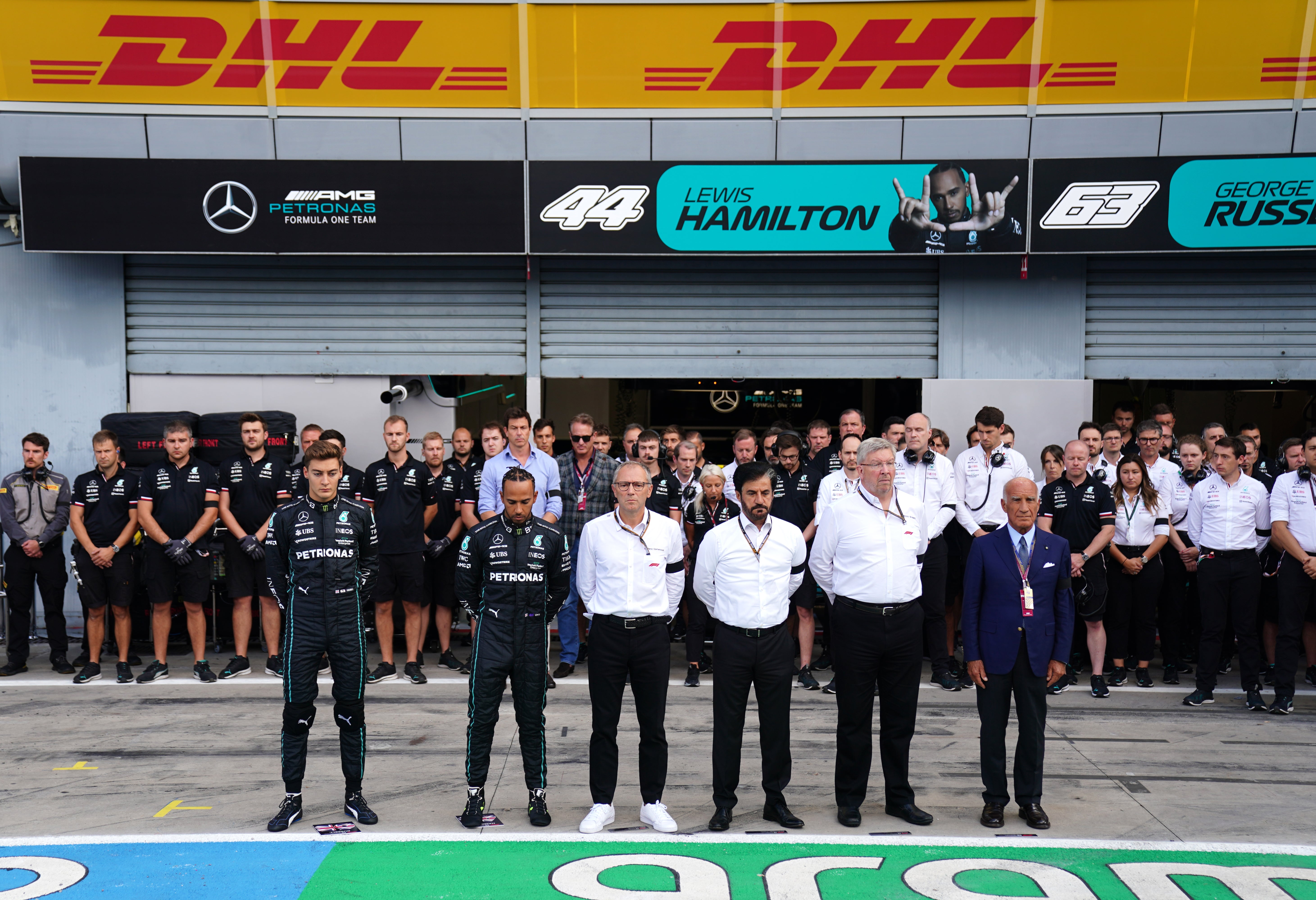 Mercedes’ George Russell, left, and Lewis Hamilton observe a minute’s silence alongside F1 CEO Stefano Domenicali, centre left, and FIA president Mohammed ben Sulayem, centre right, and managing director Ross Brawn (David Davies/PA)