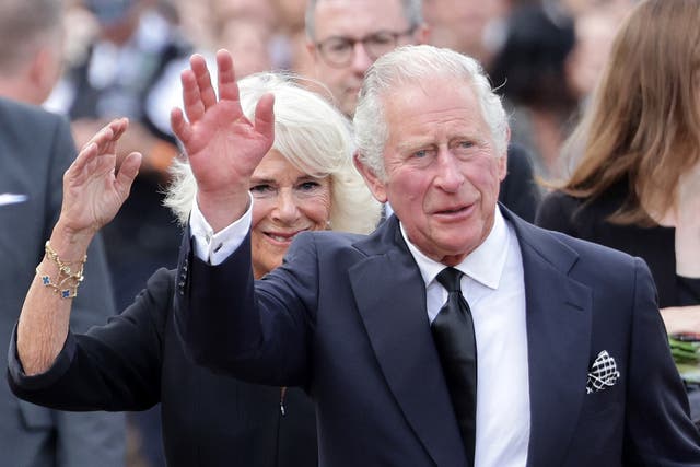 <p>King Charles III and Camilla, Queen Consort wave after viewing floral tributes to the late Queen Elizabeth II outside Buckingham Palace</p>