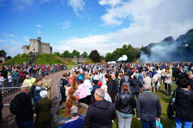 Spectators watch members of the 104 Regiment Royal Artillery during the Gun Salute at Cardiff Castle (PA)