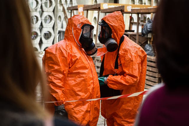 <p>Ukrainian Emergency Ministry rescuers wear protective clothing during a nuclear emergency training session for civilians</p>