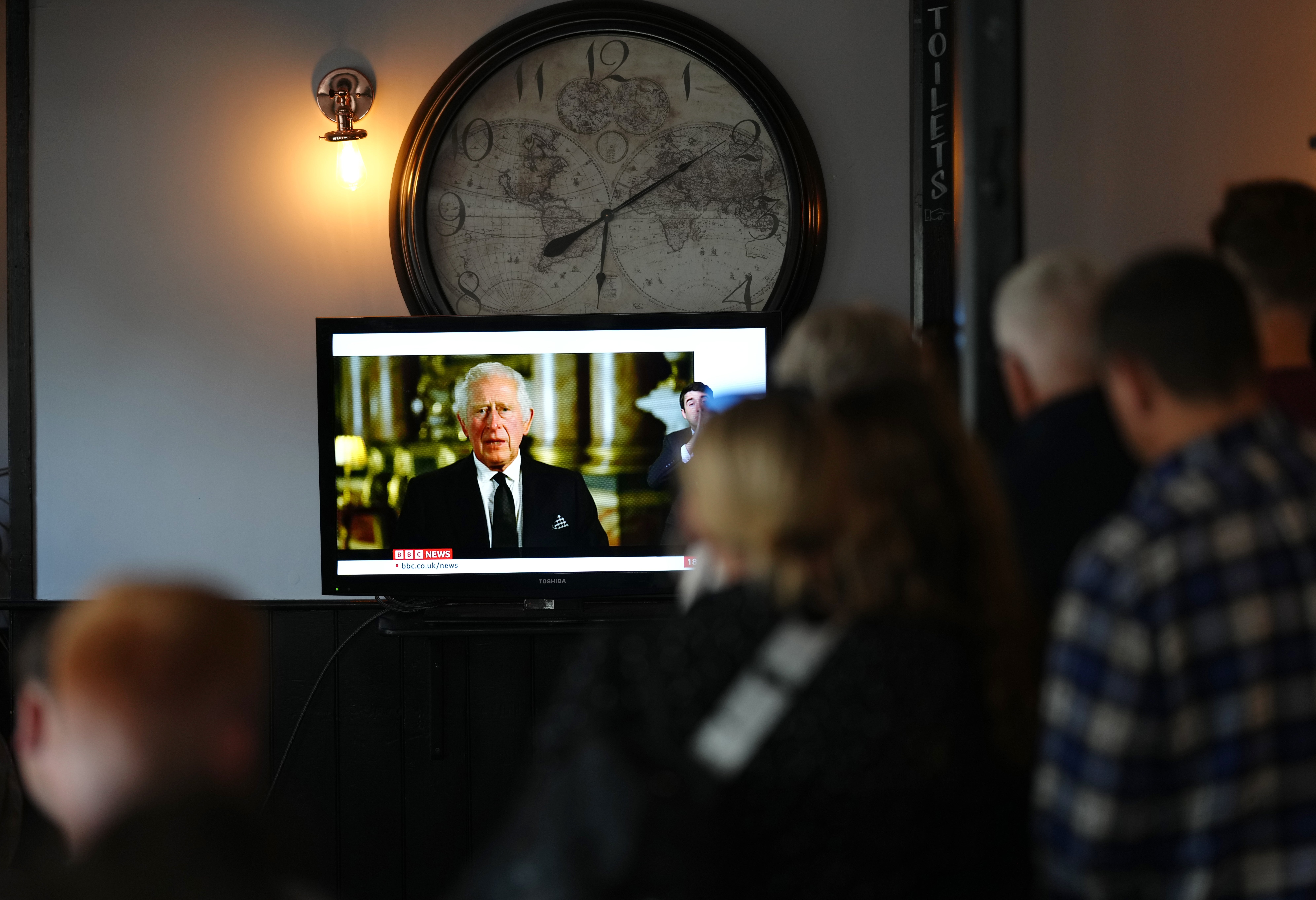 Members of the public in The Prince Harry Pub, Windsor, watching a broadcast of King Charles III (John Walton/PA)
