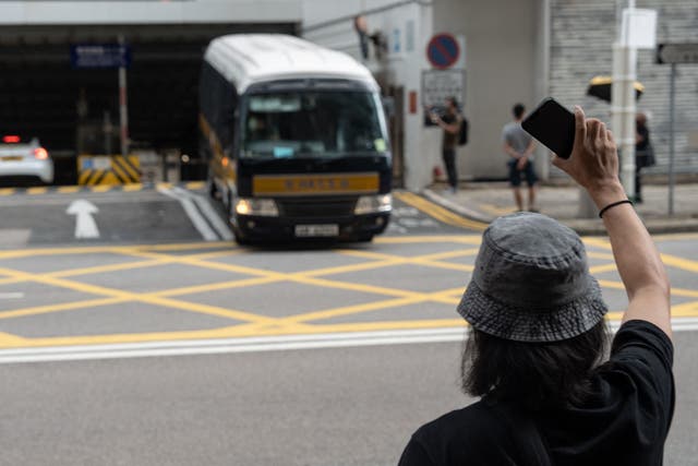 <p>A supporter of a pro-democracy union waves at a prison van at the Wanchai district court in Hong Kong on 10 September 2022, where members of the union are sentenced for 19 months in jail for the charges of sedition</p>