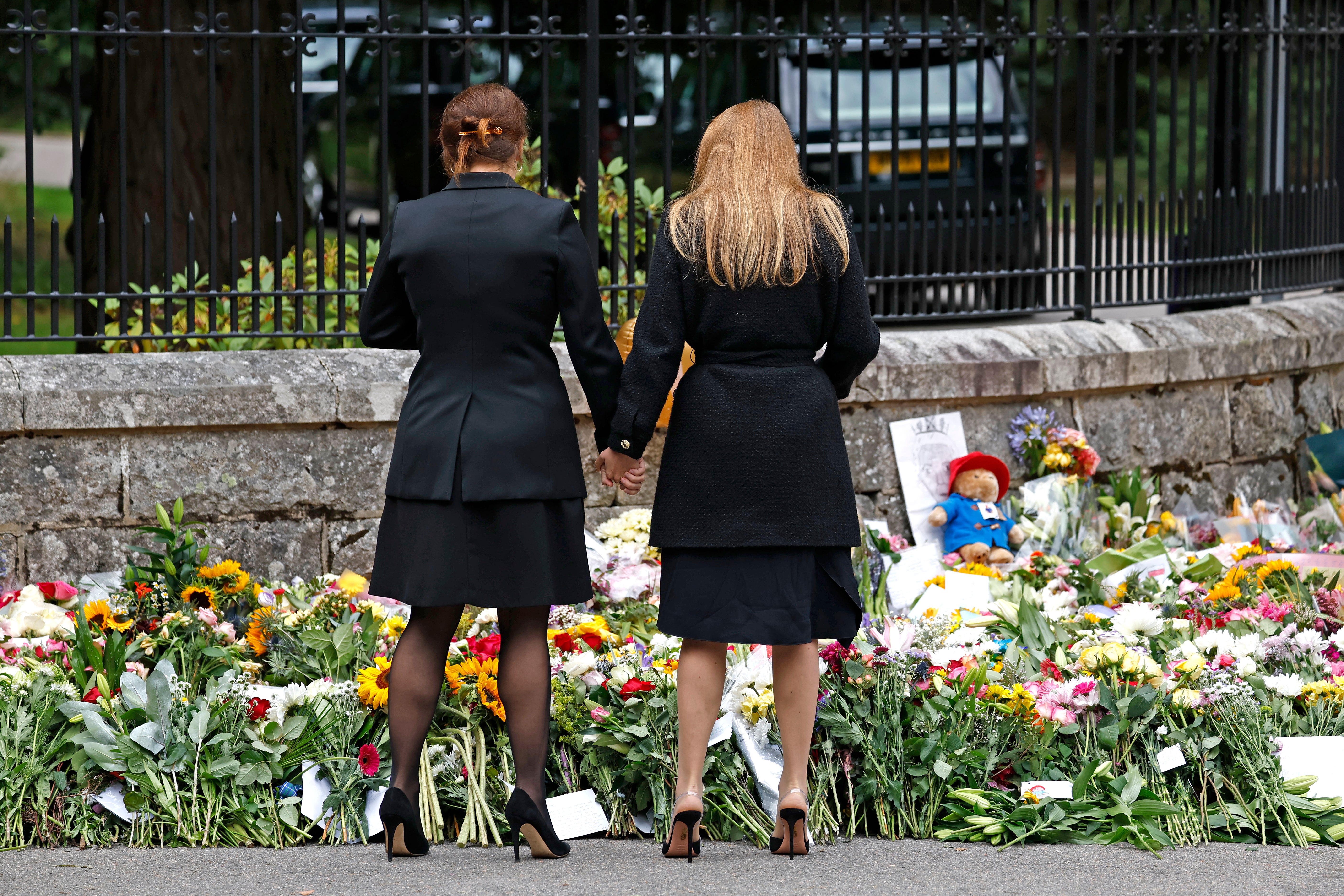 The sisters spent time looking at the masses of flowers left by well wishers