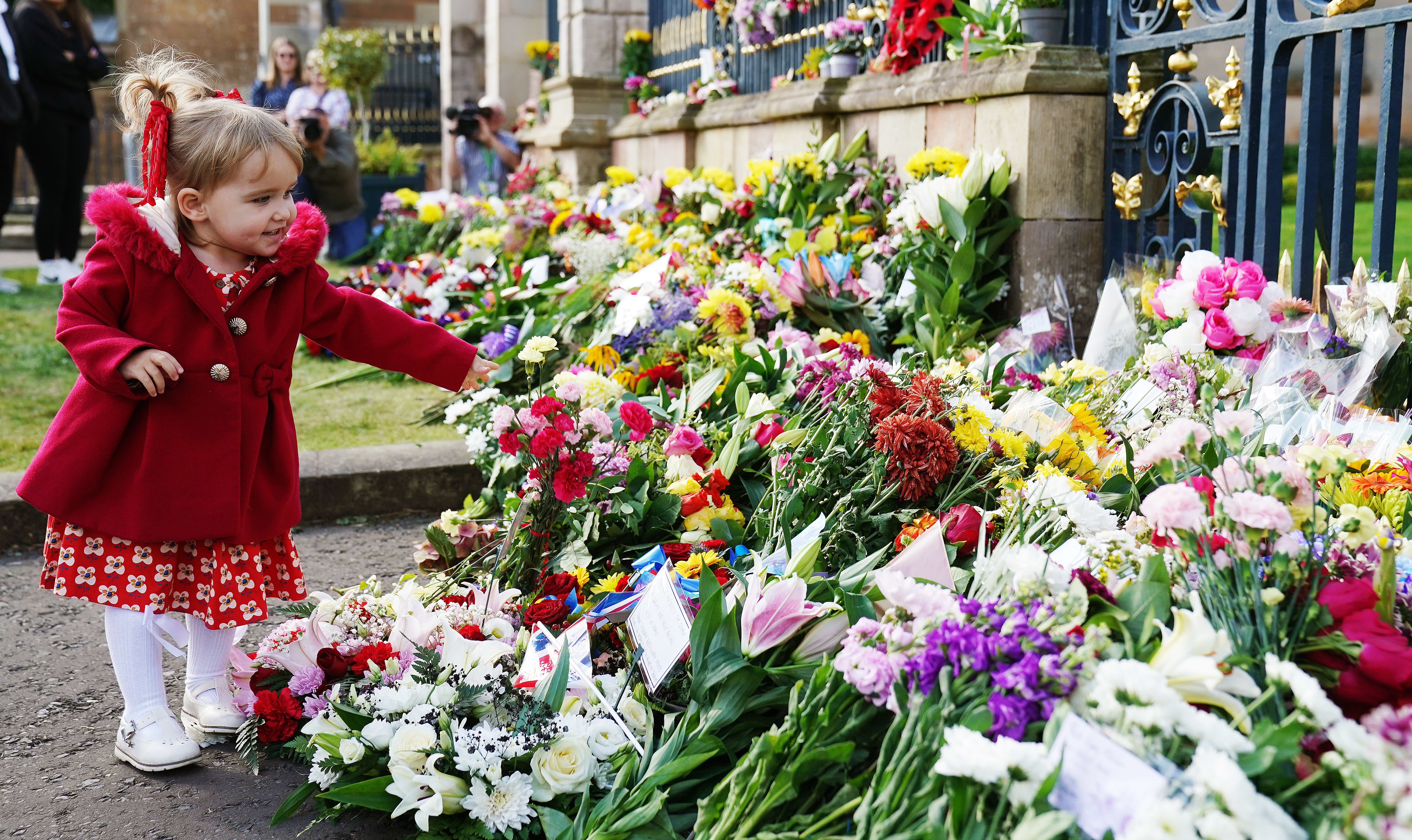 Abigail Glen, from Lisburn, lays flowers at the gates of Hillsborough Castle in Co Down (Brian Lawless/PA)