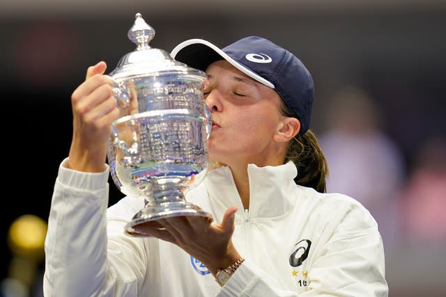 <p>Iga Swiatek kisses the US Open trophy</p>