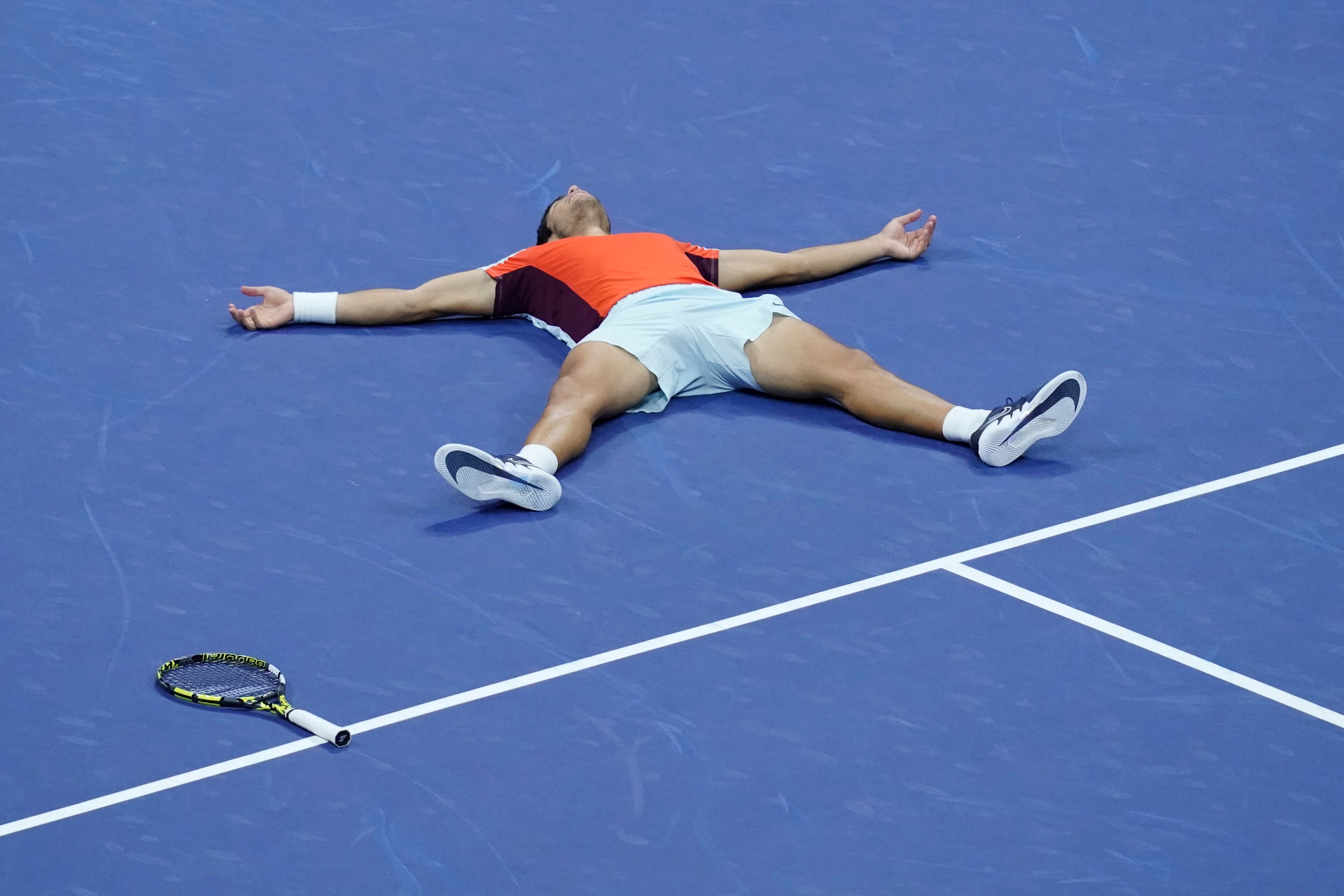 Carlos Alcaraz lies on the court after winning the title (Mary Altaffer/AP)