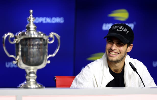 <p>Carlos Alcaraz beams after securing his first major trophy</p>