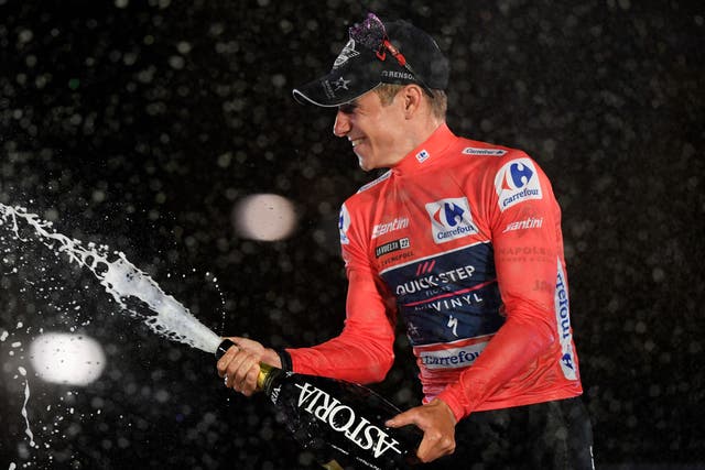 <p>Remco Evenepoel spray champagne on the winner’s podium in Madrid</p>