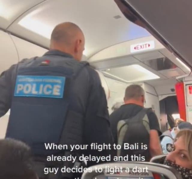 <p>Police escort the man off the Bali flight</p>