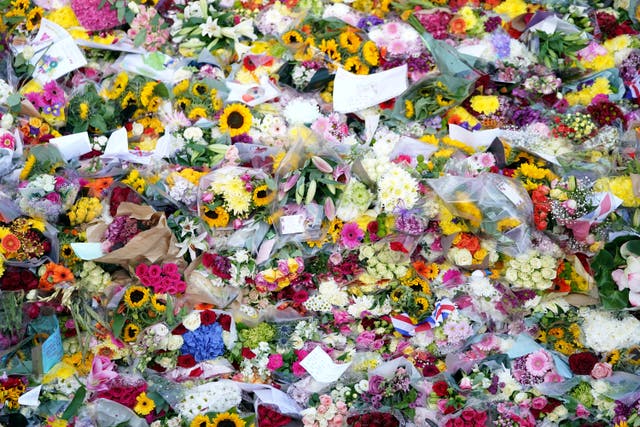 Piles of flowers at Buckingham Palace, London, following the death of the Queen (Zac Goodwin/PA)