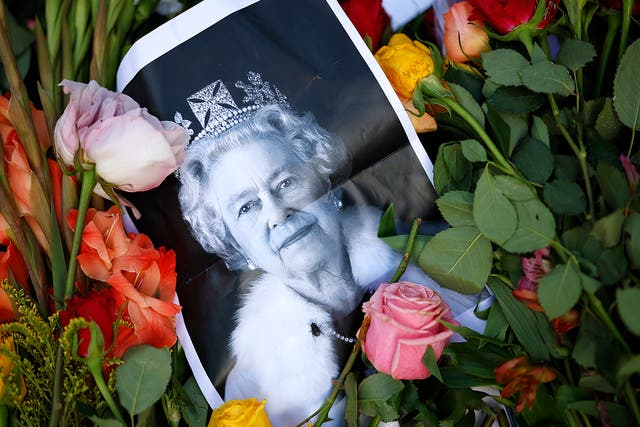 <p>A photograph of Queen Elizabeth II lays among flowers left at a memorial site near Buckingham Palace this weekend</p>