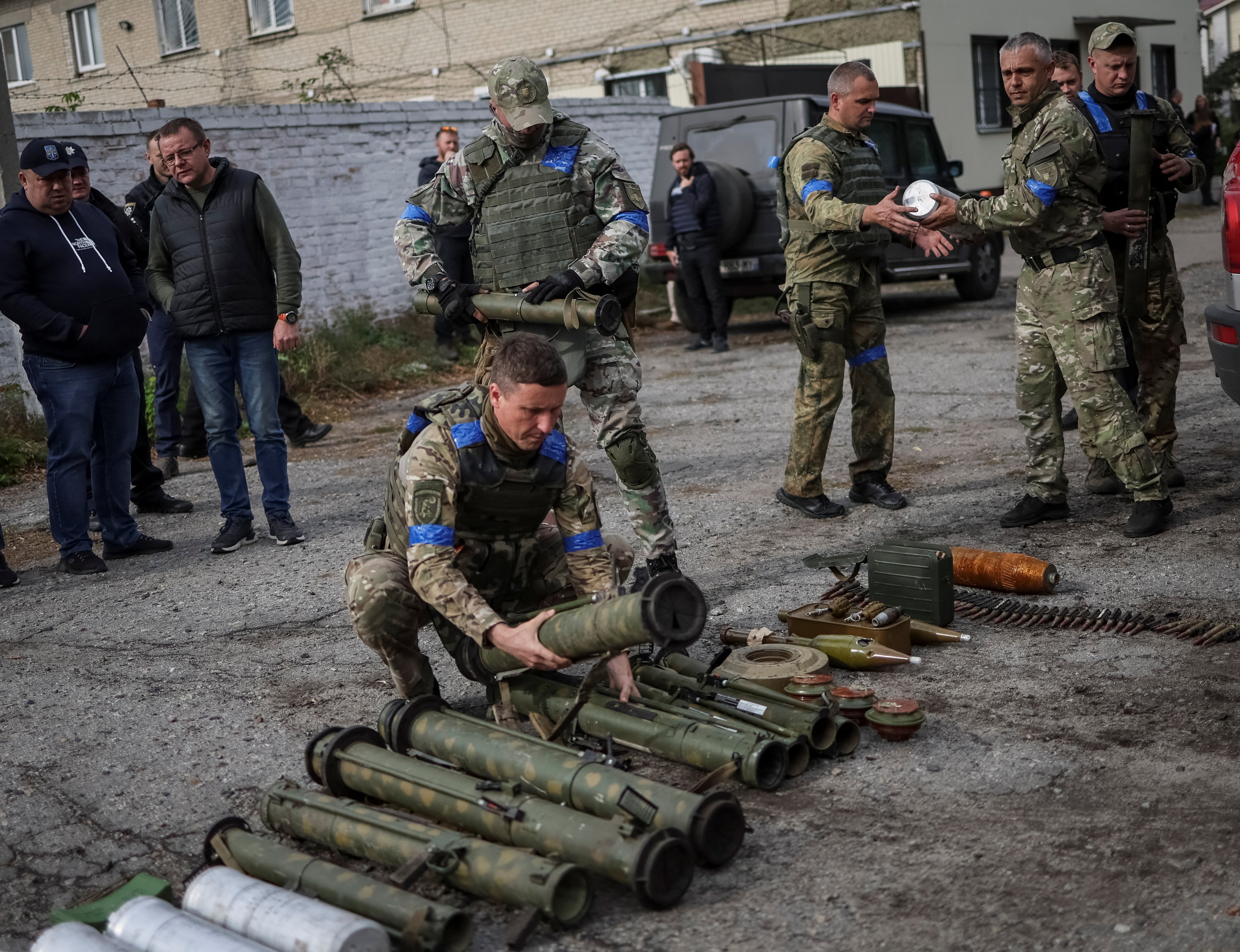 A police sapper sorts unexploded mine shells and weapons after return from the village of Udy, recently liberated by Ukrainian Armed Forces, in the town of Zolochiv, Kharkiv region