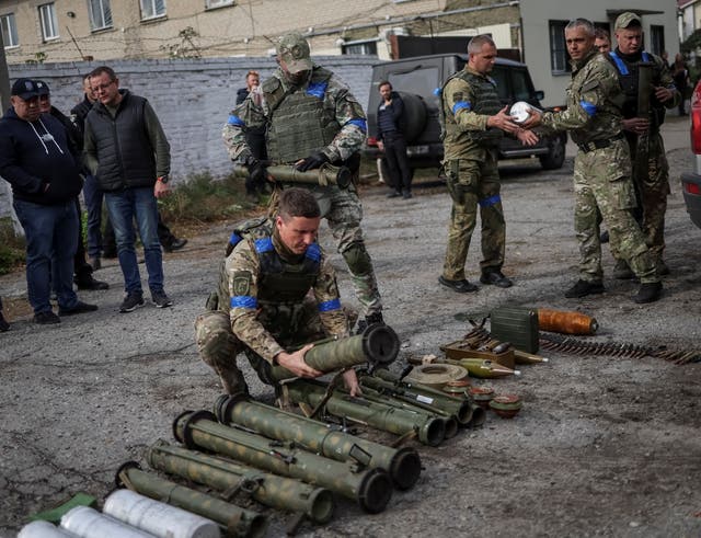 <p>A police sapper sorts unexploded mine shells and weapons after return from the village of Udy, recently liberated by Ukrainian Armed Forces, in the town of Zolochiv, Kharkiv region</p>