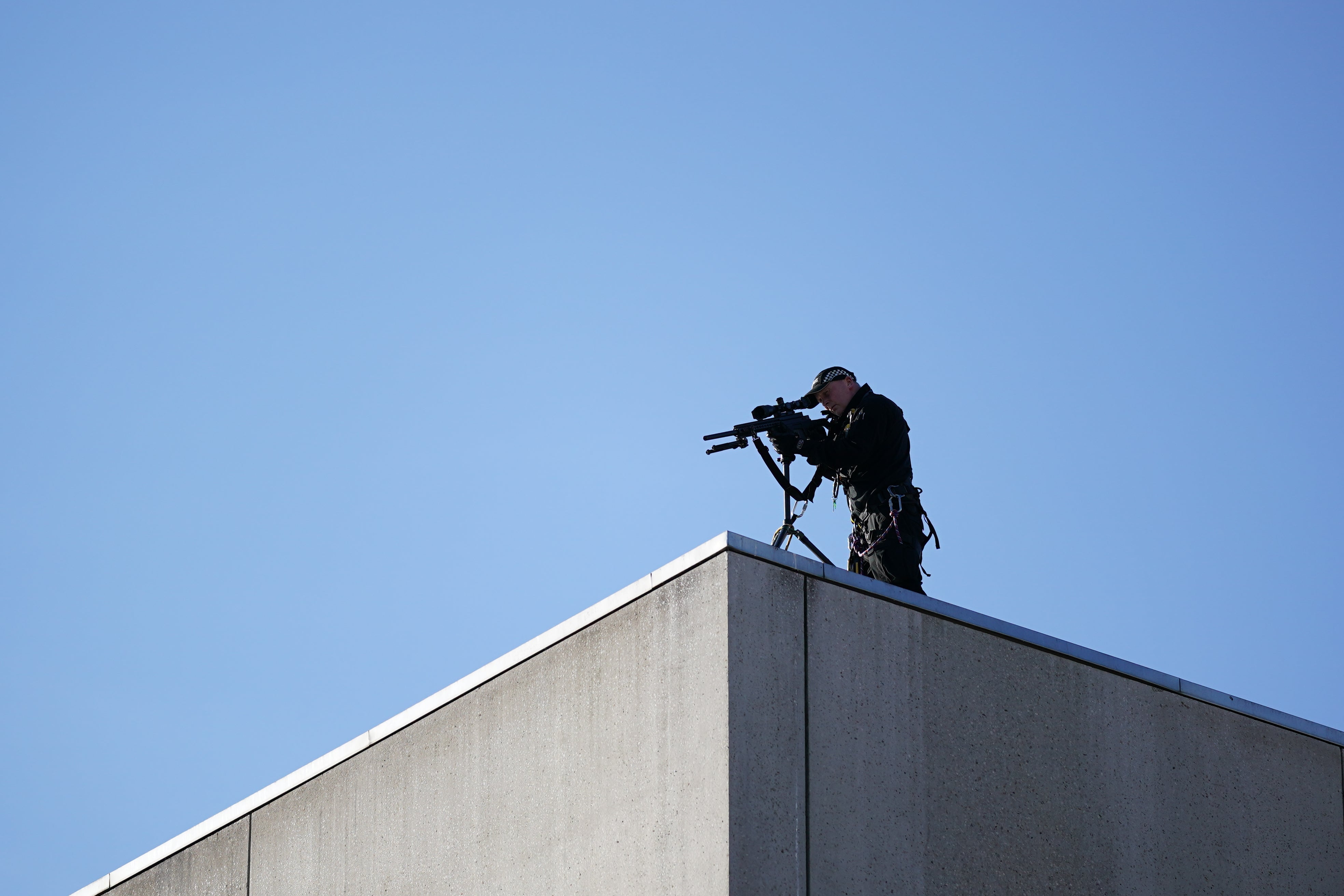 A police sniper watches over the Palace of Holyroodhouse