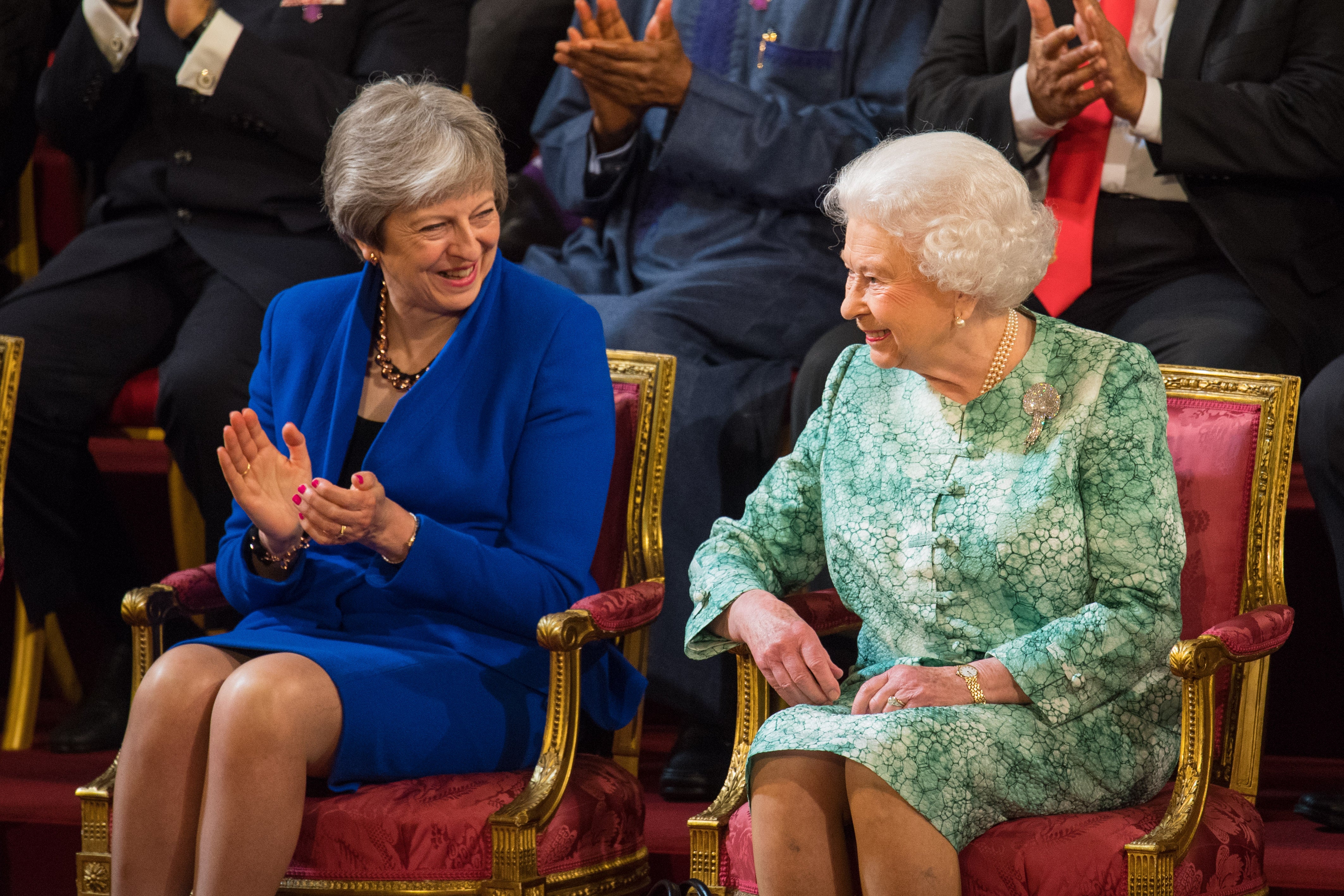 Former prime minster Theresa May sits with Queen Elizabeth II in April 2018