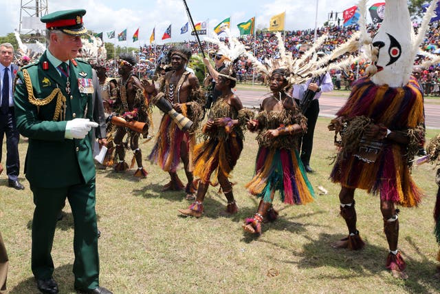 The then Prince of Wales meets dancers dressed in traditional dress during a visit to the Sir John Guise Stadium in Papua New Guinea in 2012 (Chris Radburn/PA)