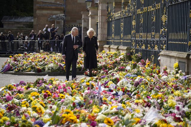 Charles and Camilla view floral tributes left outside Hillsborough Castle (Niall Carson/PA)