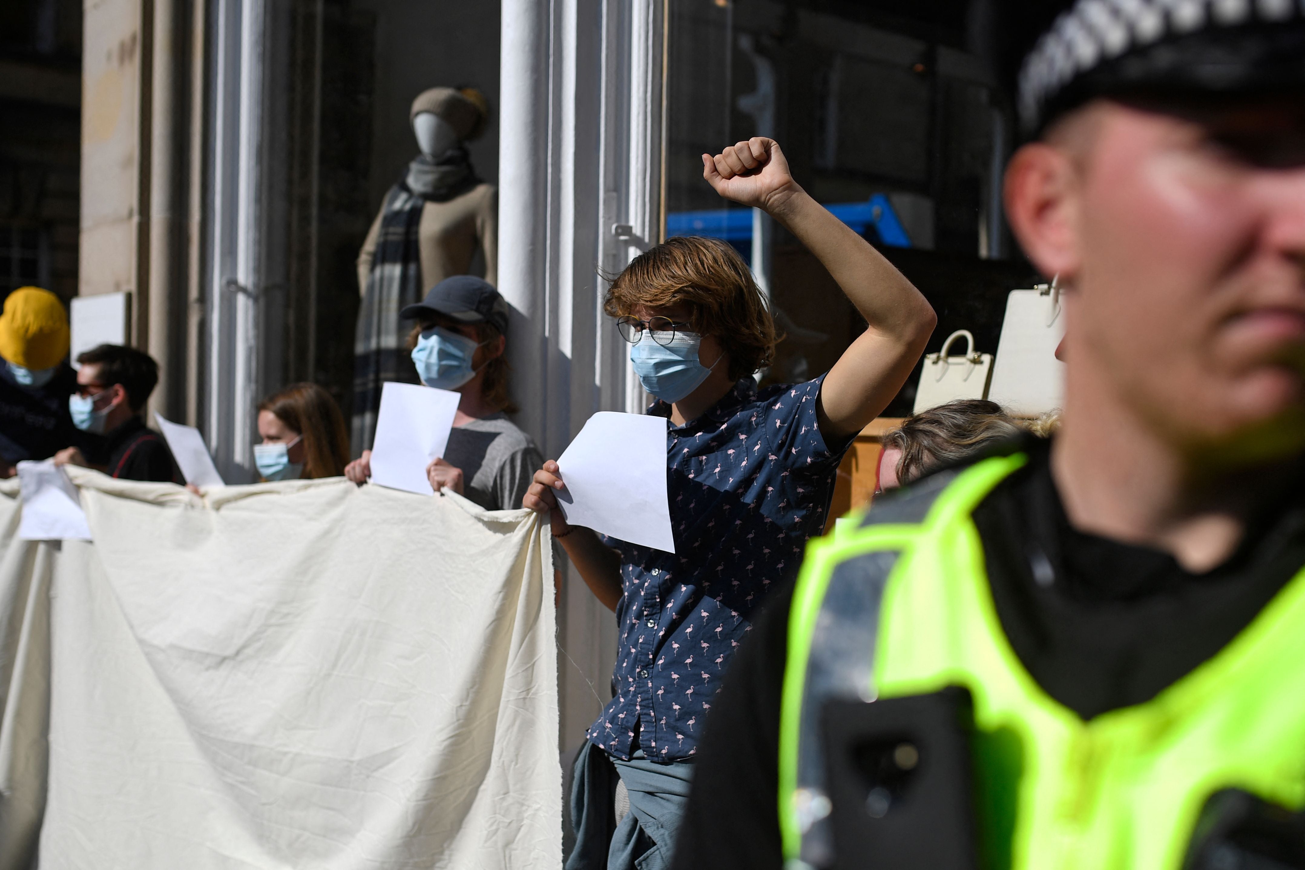 People holding blank placards in a demonstration against police action over anti-monarchy protests in Scotland