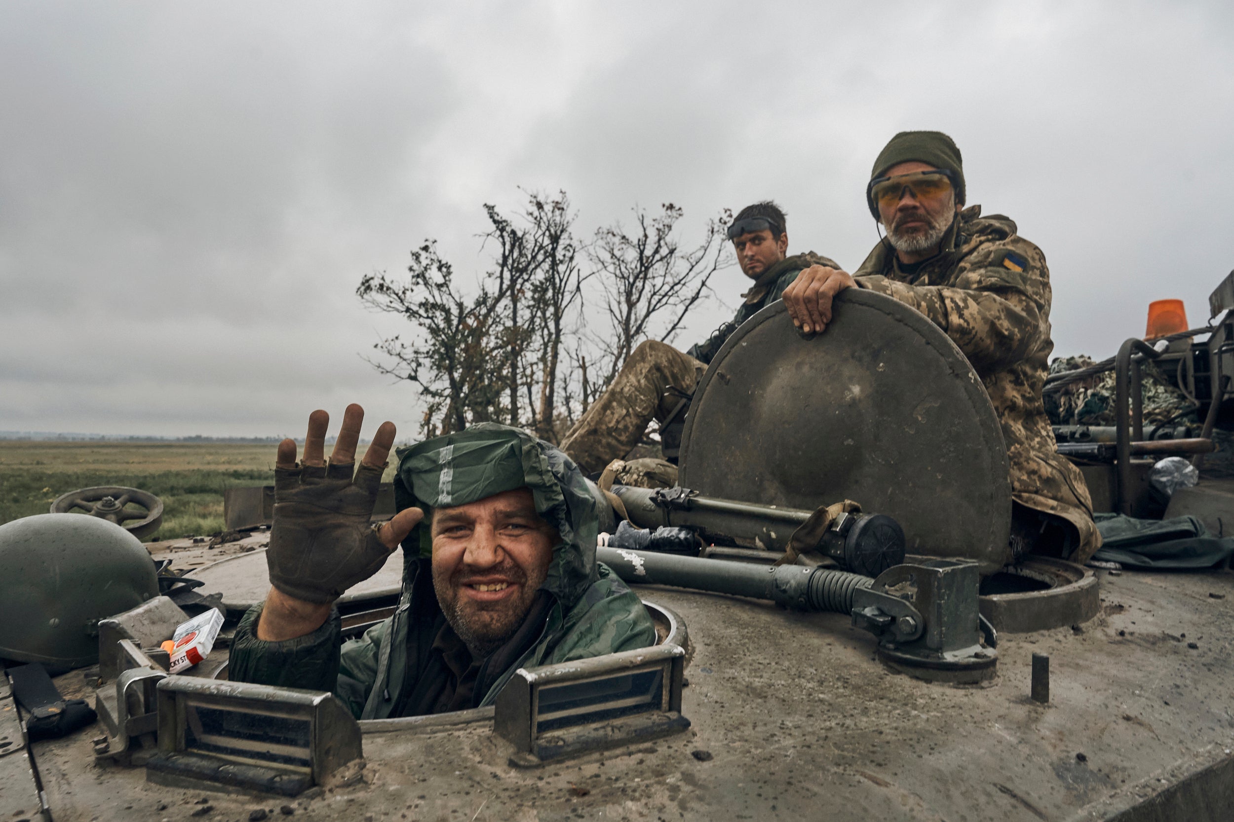 A Ukrainian soldier smiles from a military vehicle in the freed territory in the Kharkiv region (Kostiantyn Liberov/AP)