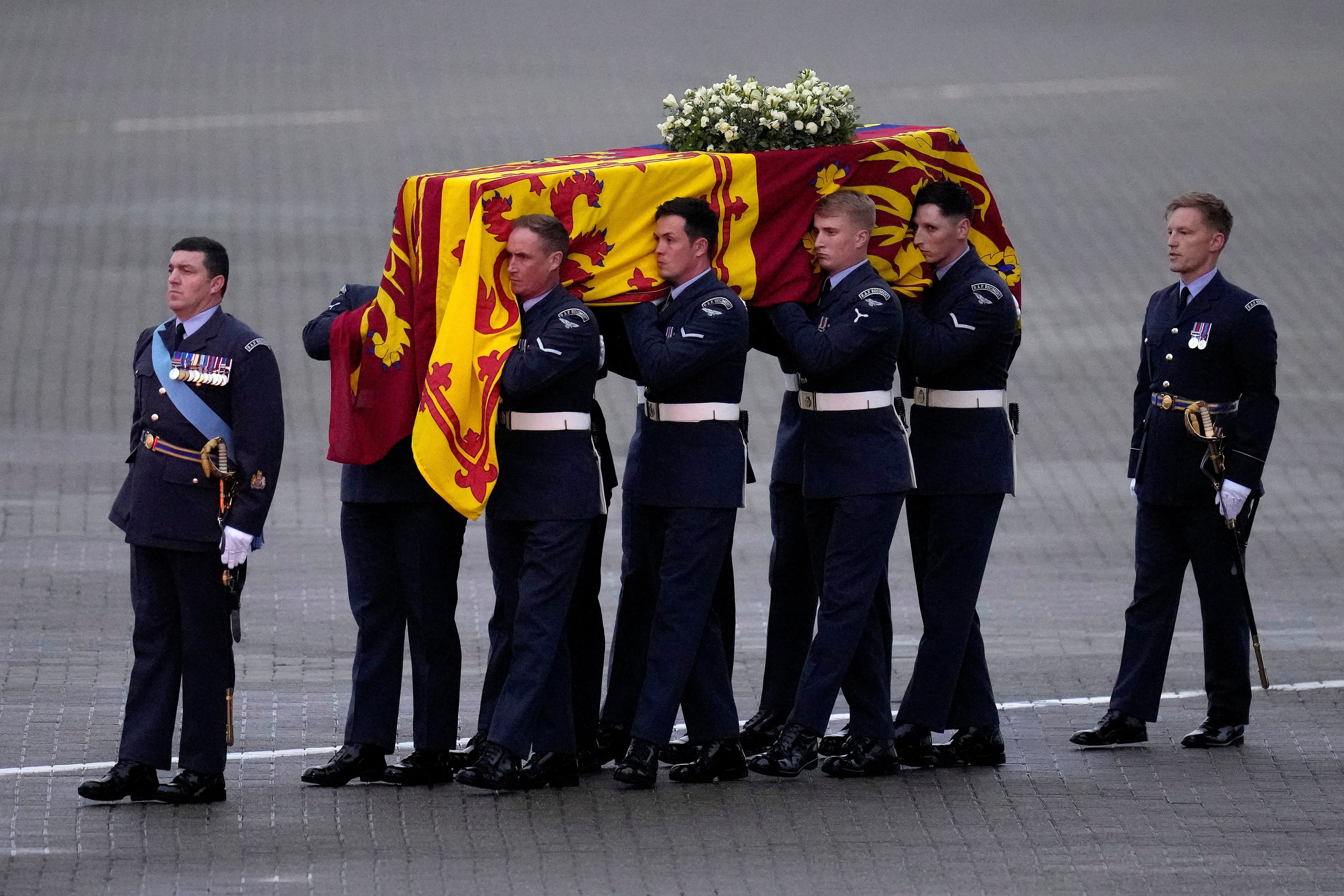 The Queen’s coffin is carried off a plane by the Queen’s Colour Squadron at RAF Northolt