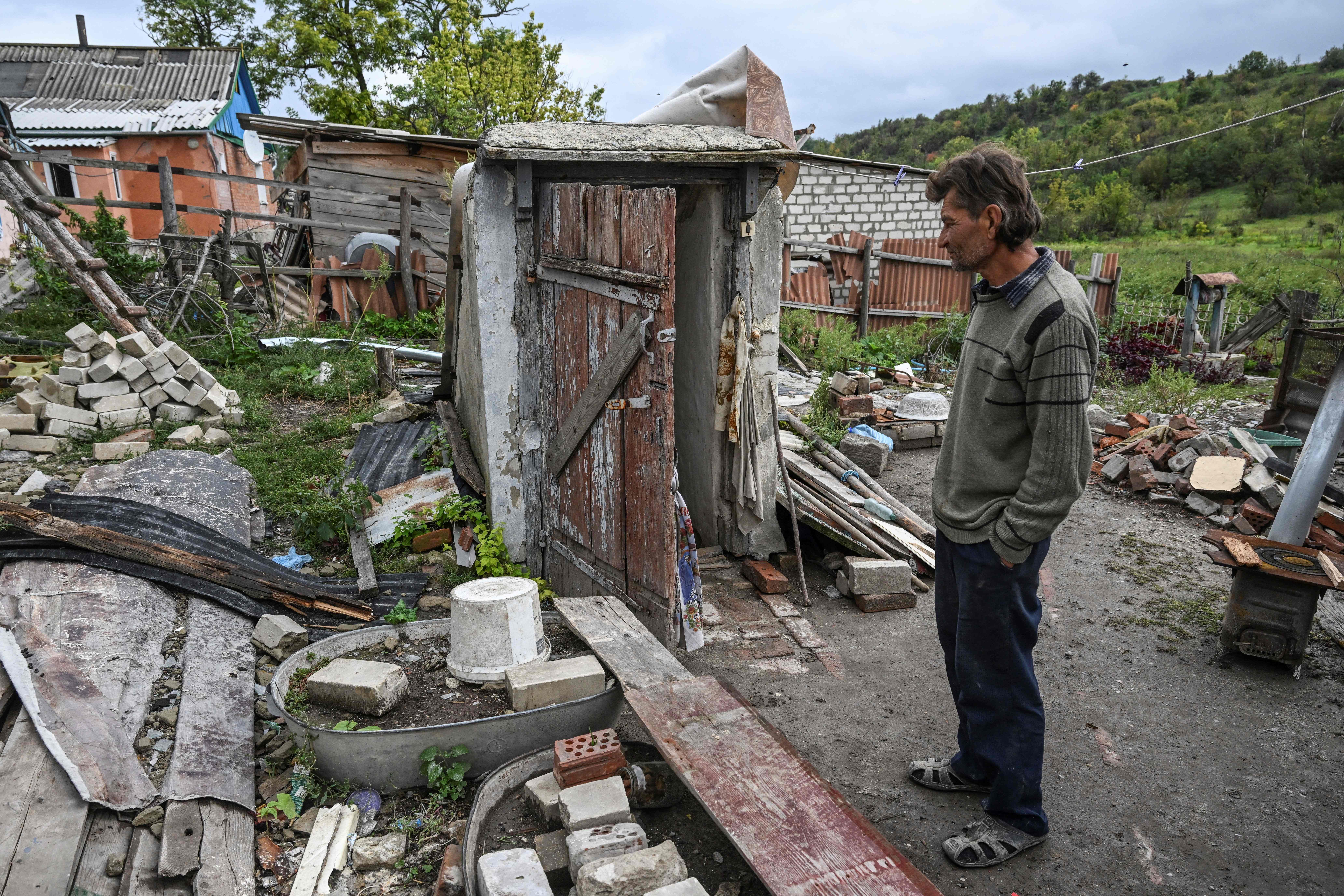 Man stands in front of a destroyed house in Bohorodychne village in Kramatorsk, Donetsk region, on 13 September 2022, amid the Russian invasion of Ukrain