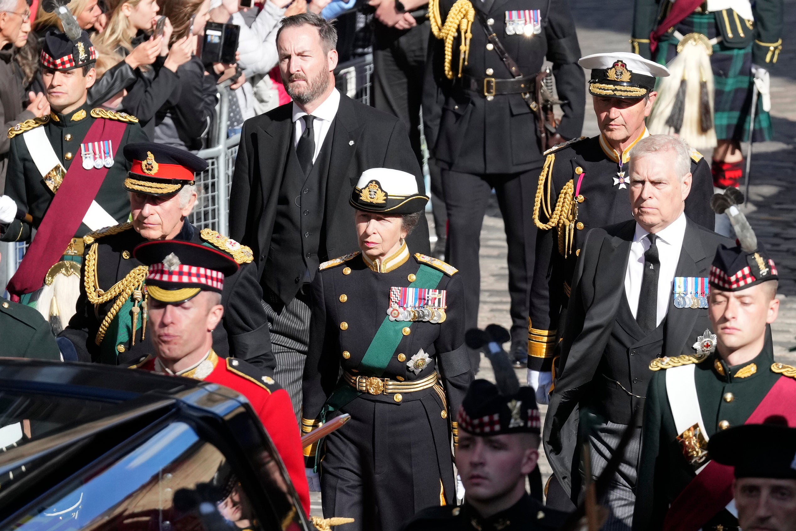 King Charles III, Princess Anne, Prince Andrew, and Vice Admiral Timothy Laurence walk behind the hearse carrying Queen Elizabeth II’s coffin on Monday