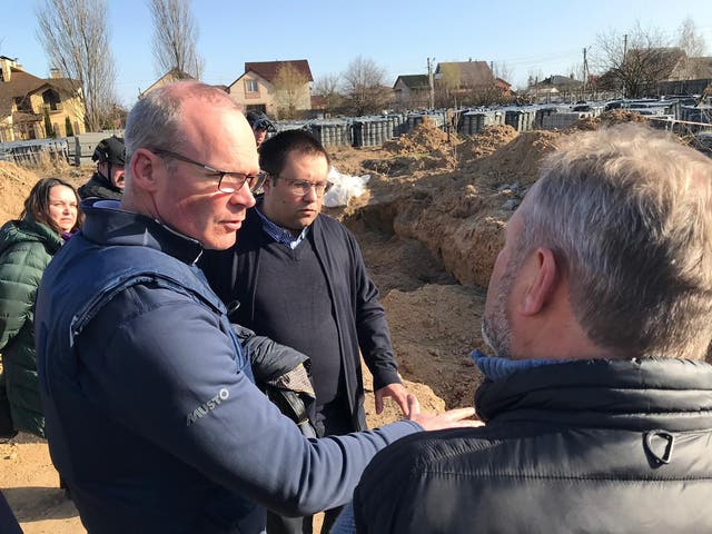 Ireland’s Minister for Foreign Affairs Simon Coveney being shown the site of mass graves in Bucha earlier this year (Department of Foreign Affairs/PA)