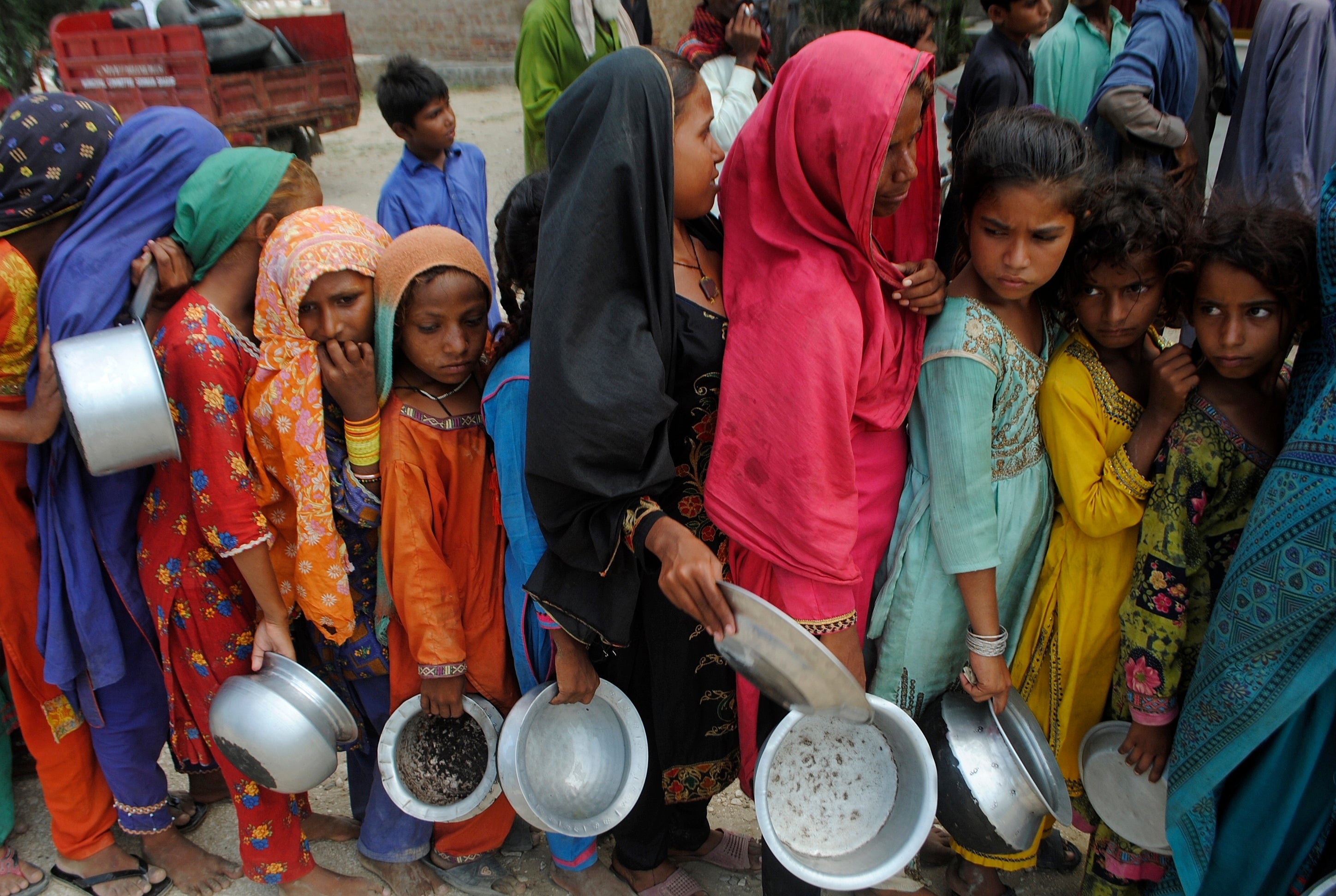 Victims of the floods in Pakistan queue for aid
