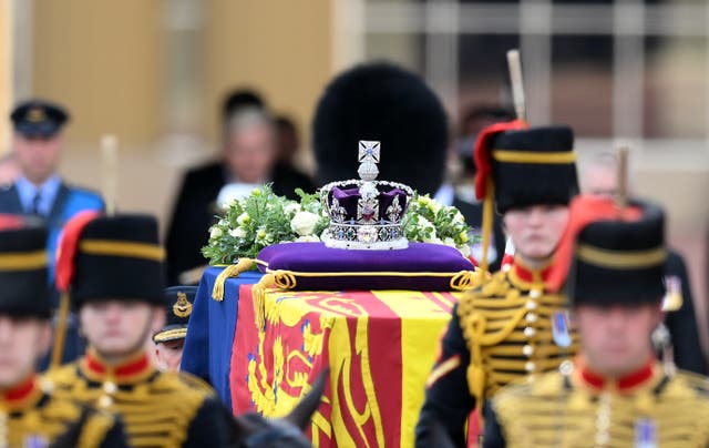 The coffin of the Queen, draped in the Royal Standard with the Imperial State Crown placed on top, is carried on a horse-drawn gun carriage (Daniel Leal/PA)