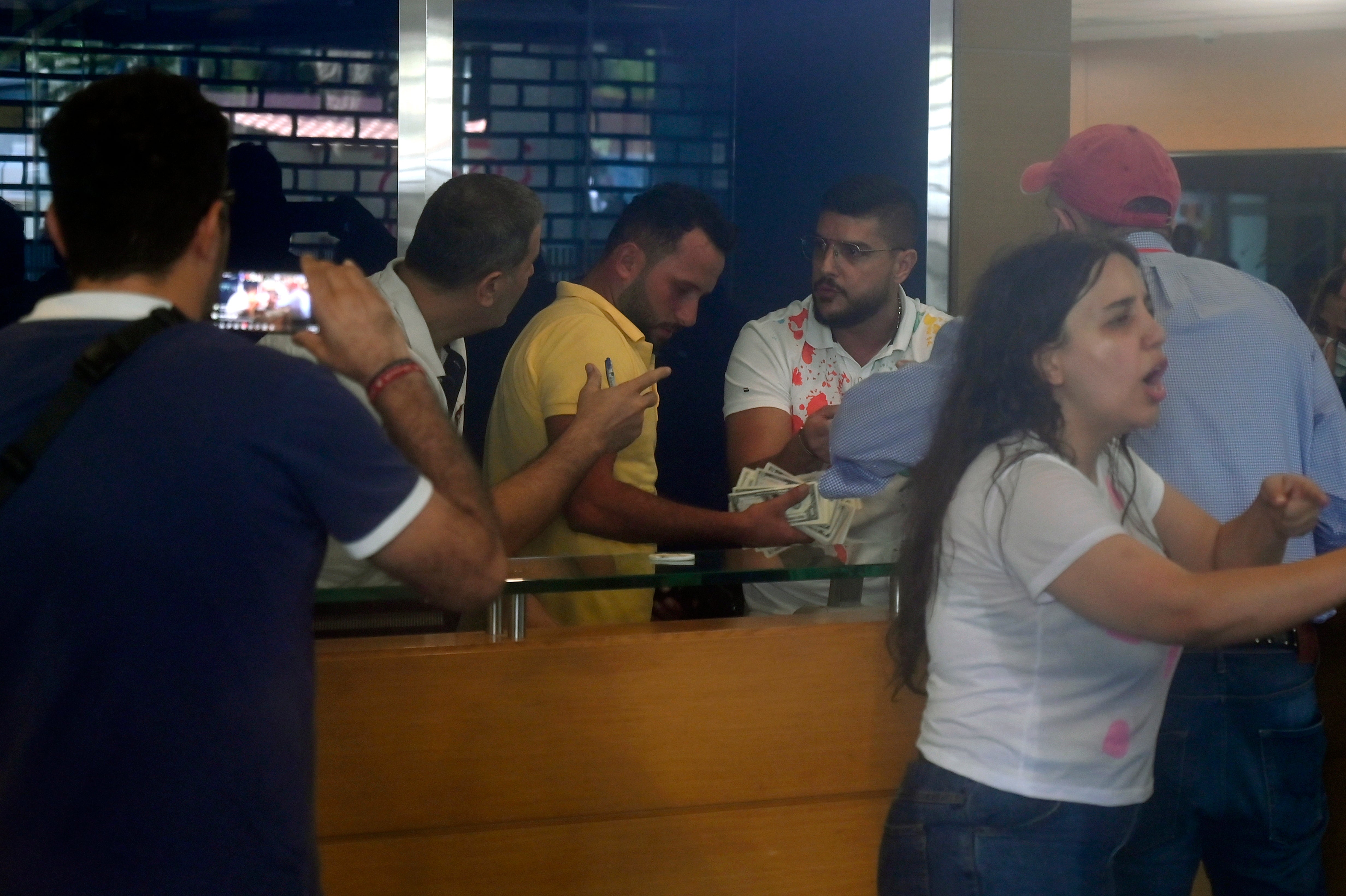 A Lebanese bank worker holds notes during the drama