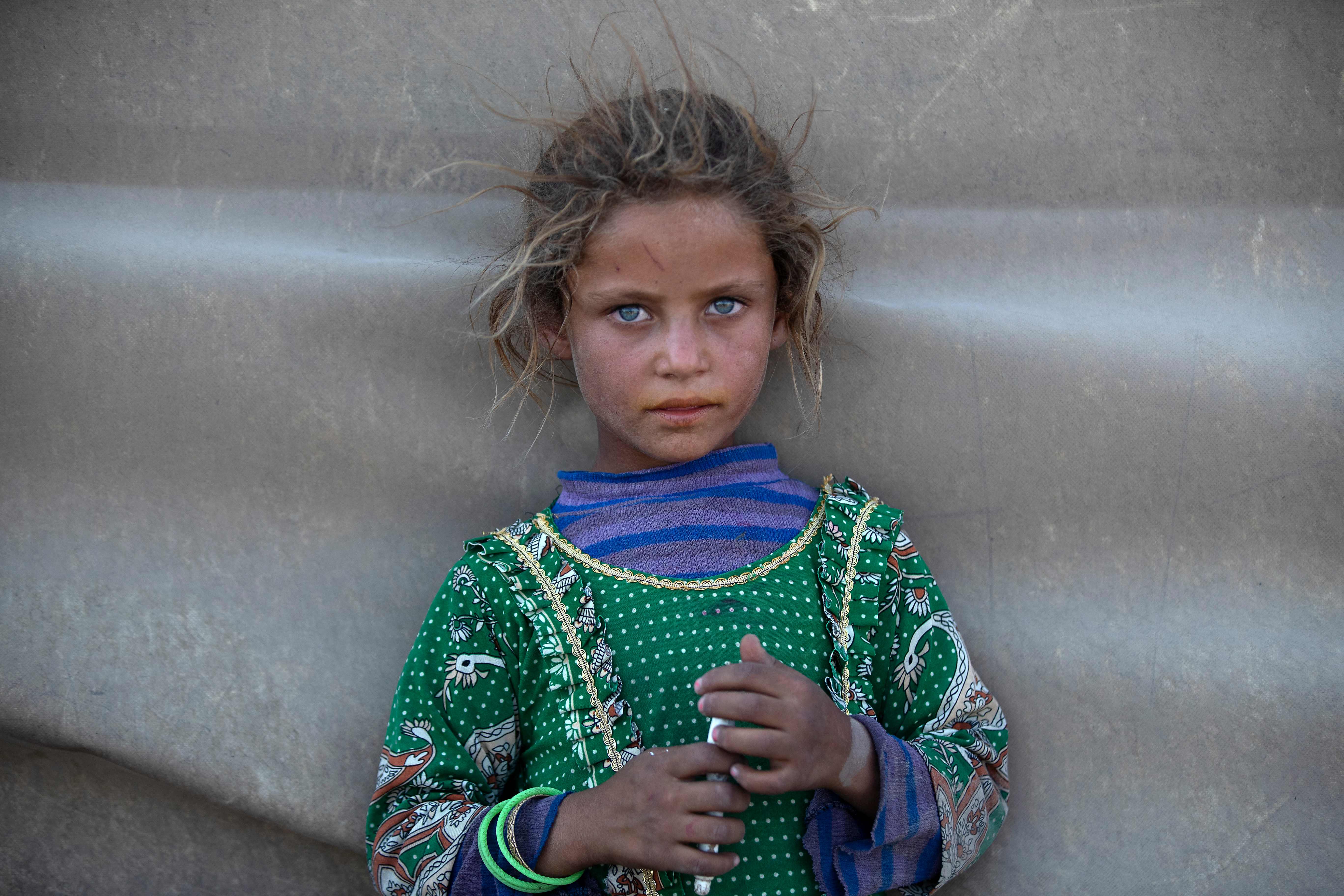 A girl stands at a camp for Syrians displaced by conflict near the northern city of Raqa