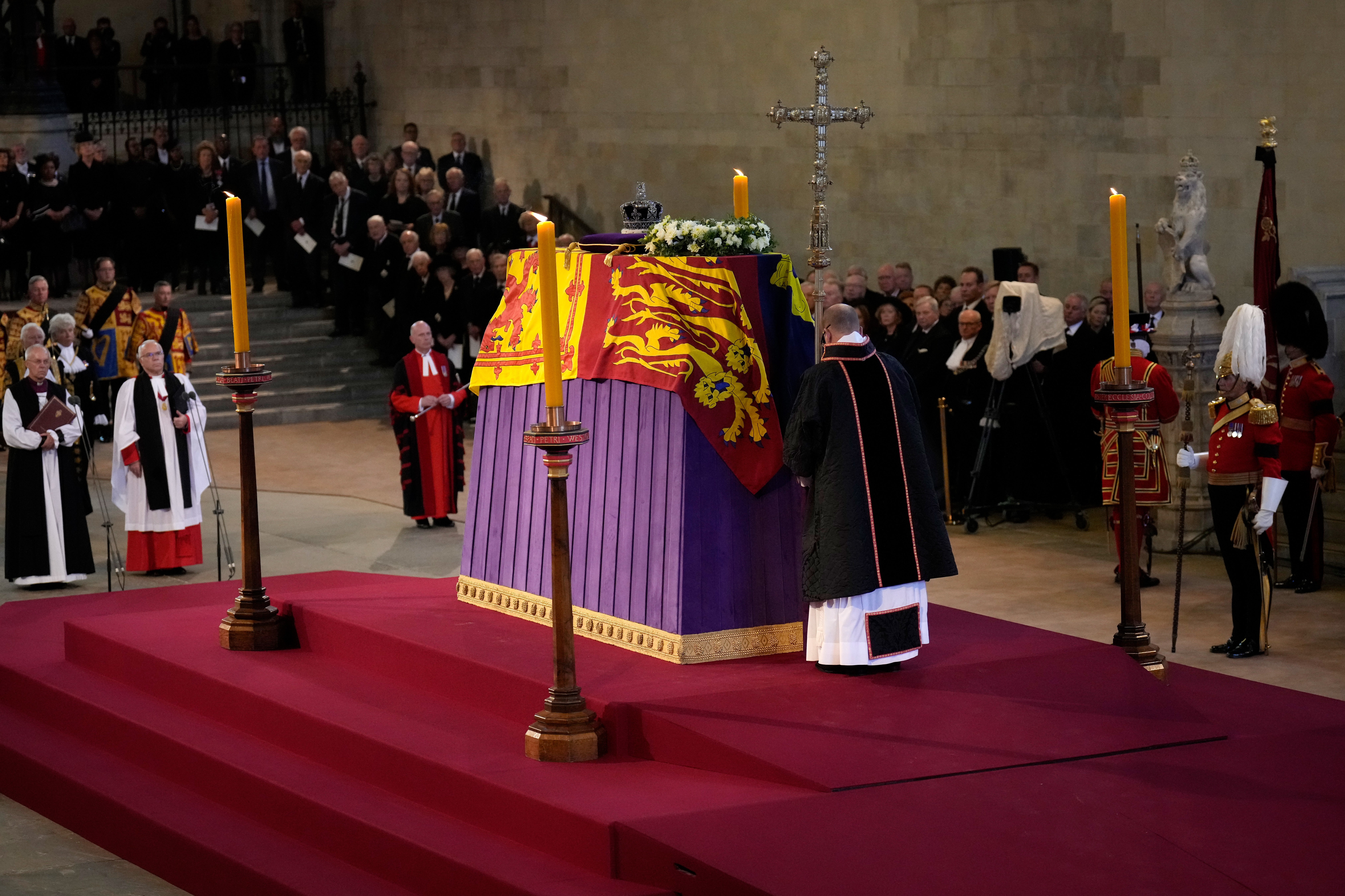 The coffin of Queen Elizabeth II, draped in the royal standard with the imperial state crown placed on top, rests on the catafalque in Westminster Hall