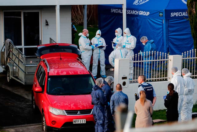 <p>New Zealand police investigators work at a scene in Auckland on 11 August 2022, after bodies were discovered in suitcases </p>