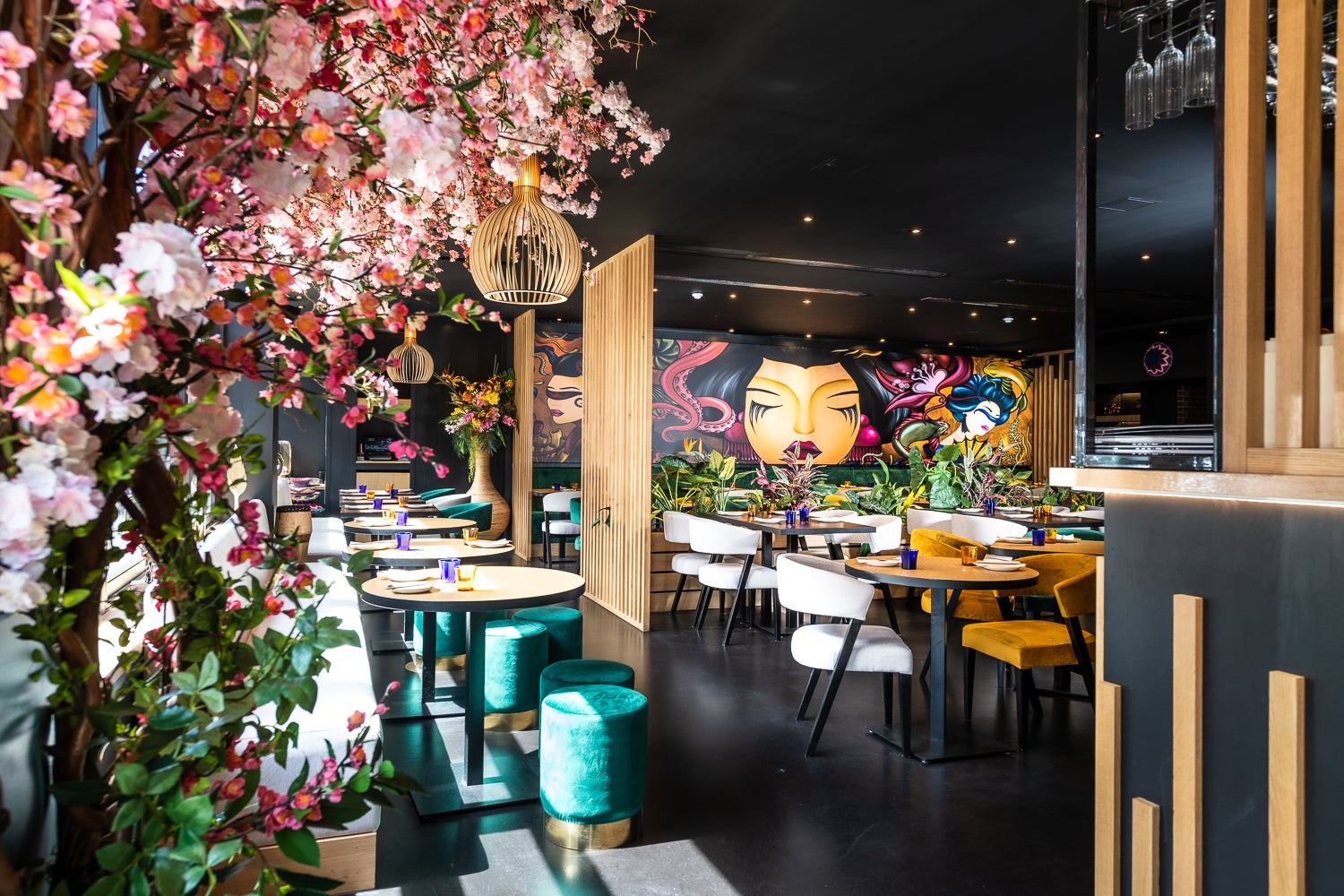 The interior at Nakanojo, featuring an explosion of faux cherry blossoms and a bold mural