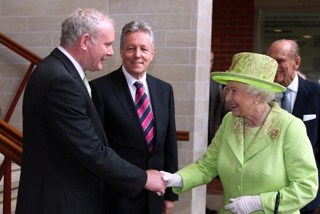 The Queen shakes hands with Northern Ireland deputy First Minister Martin McGuinness watched by First Minister Peter Robinson at the Lyric Theatre in Belfast (Paul Faith/PA)