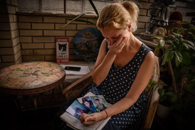 <p>Maria, a manicurist, weeps over the photos of her missing fiancé, who disappeared in battle</p>