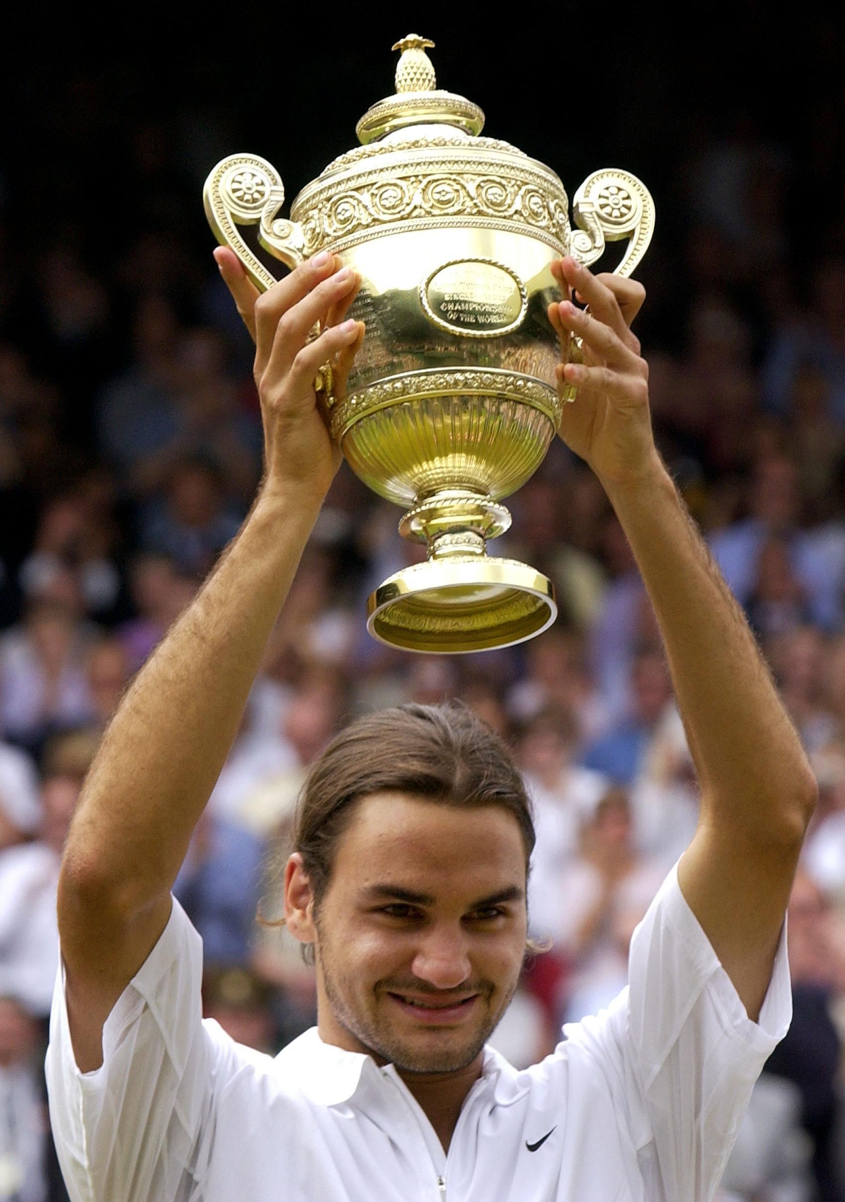 Federer celebrates after winning his first Wimbledon title. He saw off Mark Philippoussis in straight sets (Rebecca Naden/PA)