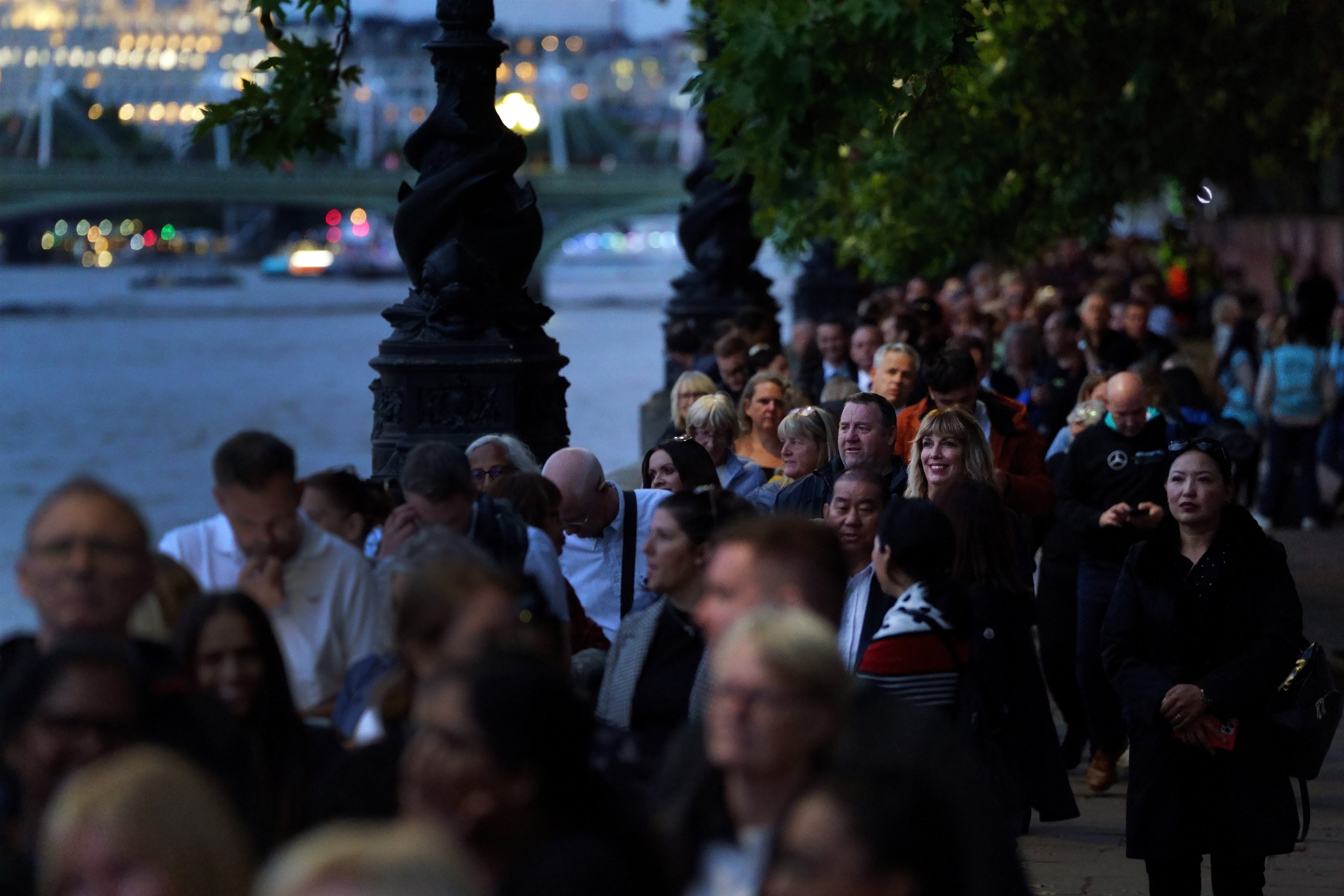 Members of the public stand in the queue on the South Bank in London opposite the Palace of Westminster (Victoria Jones/PA)
