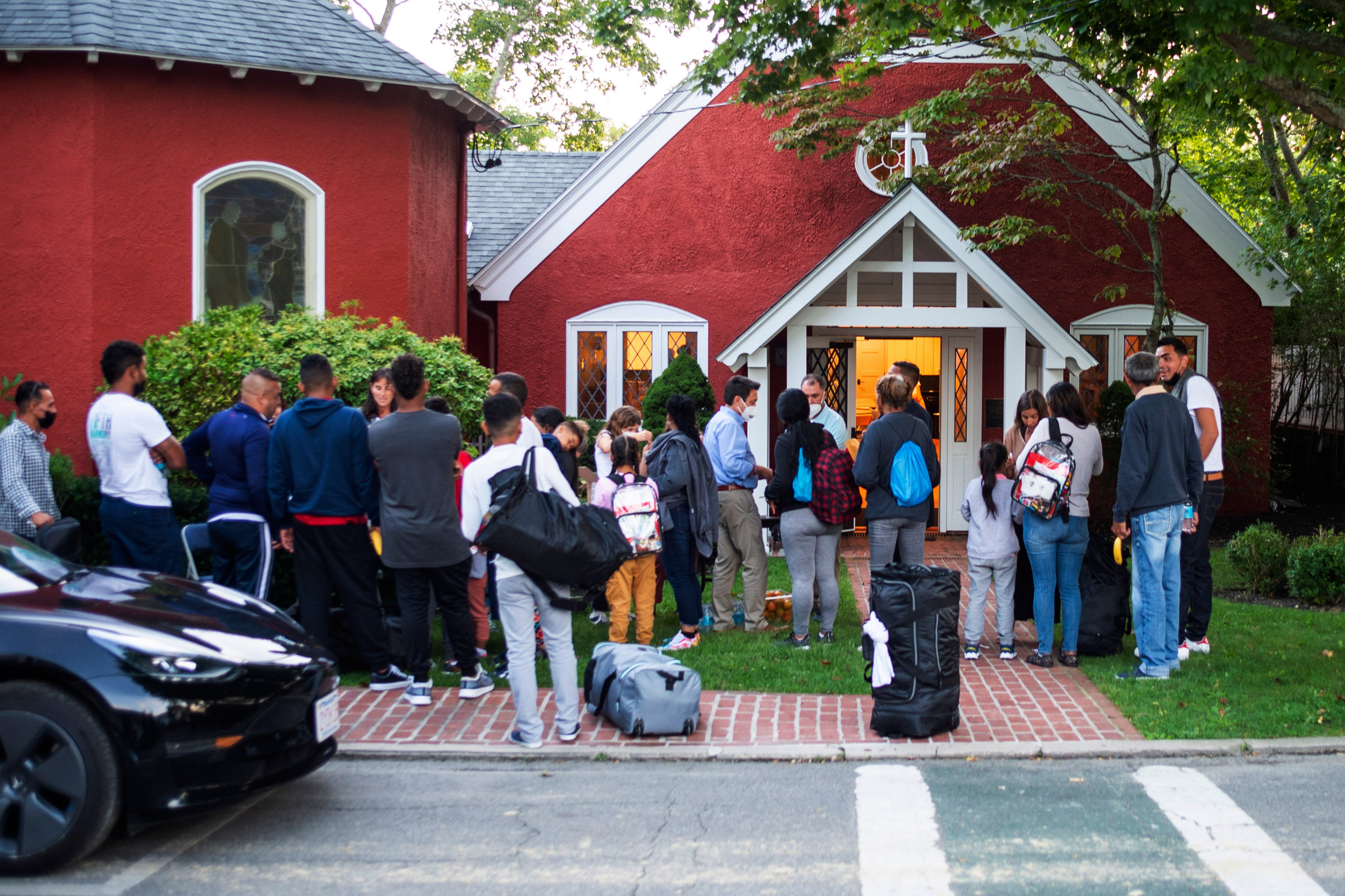 A group of migrants gather outside Martha’s Vineyard’s St Andrews Episcopal Church, which received an ‘outporing’ of support from the island