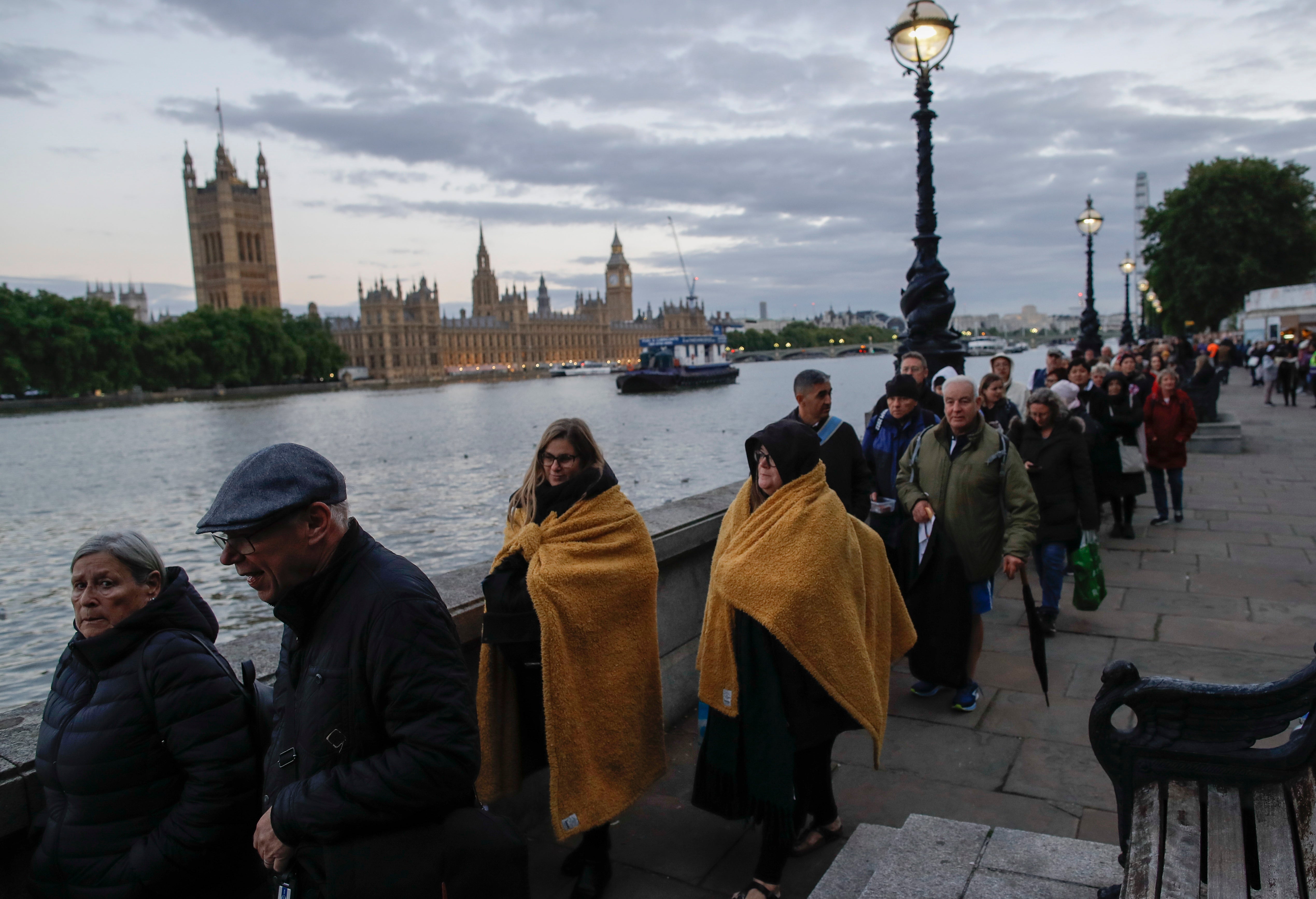People queue facing Parliament to pay their respects to Britain's Queen Elizabeth II lying in state at the Palace of Westminster in London