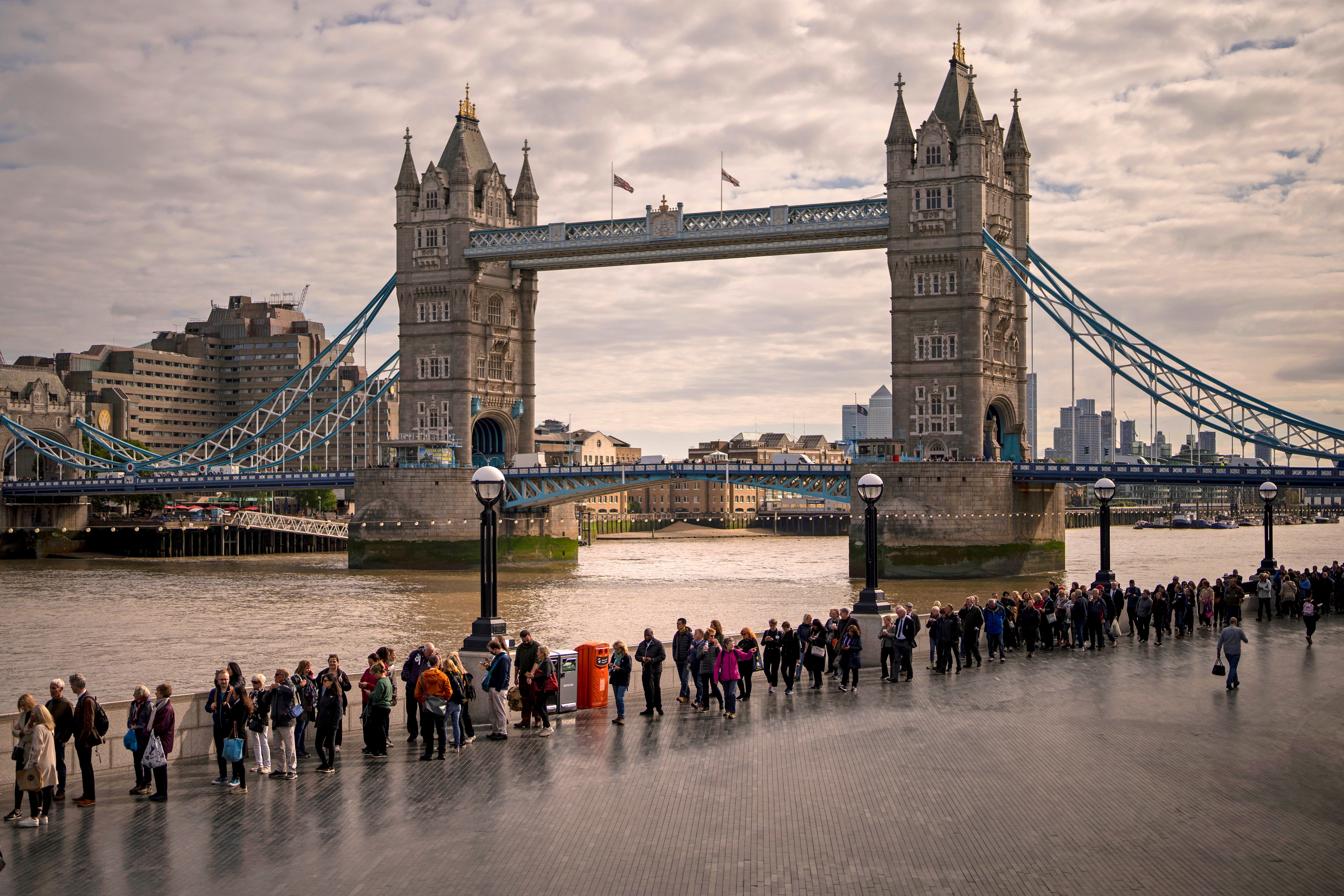 Those in the long queue to see the Queen’s lying-in-state make their way past Tower Bridge