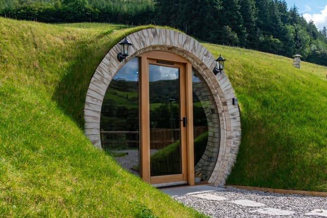 <p>The Hobbit-inspired twin huts are built into the side of a grassy mound </p>
