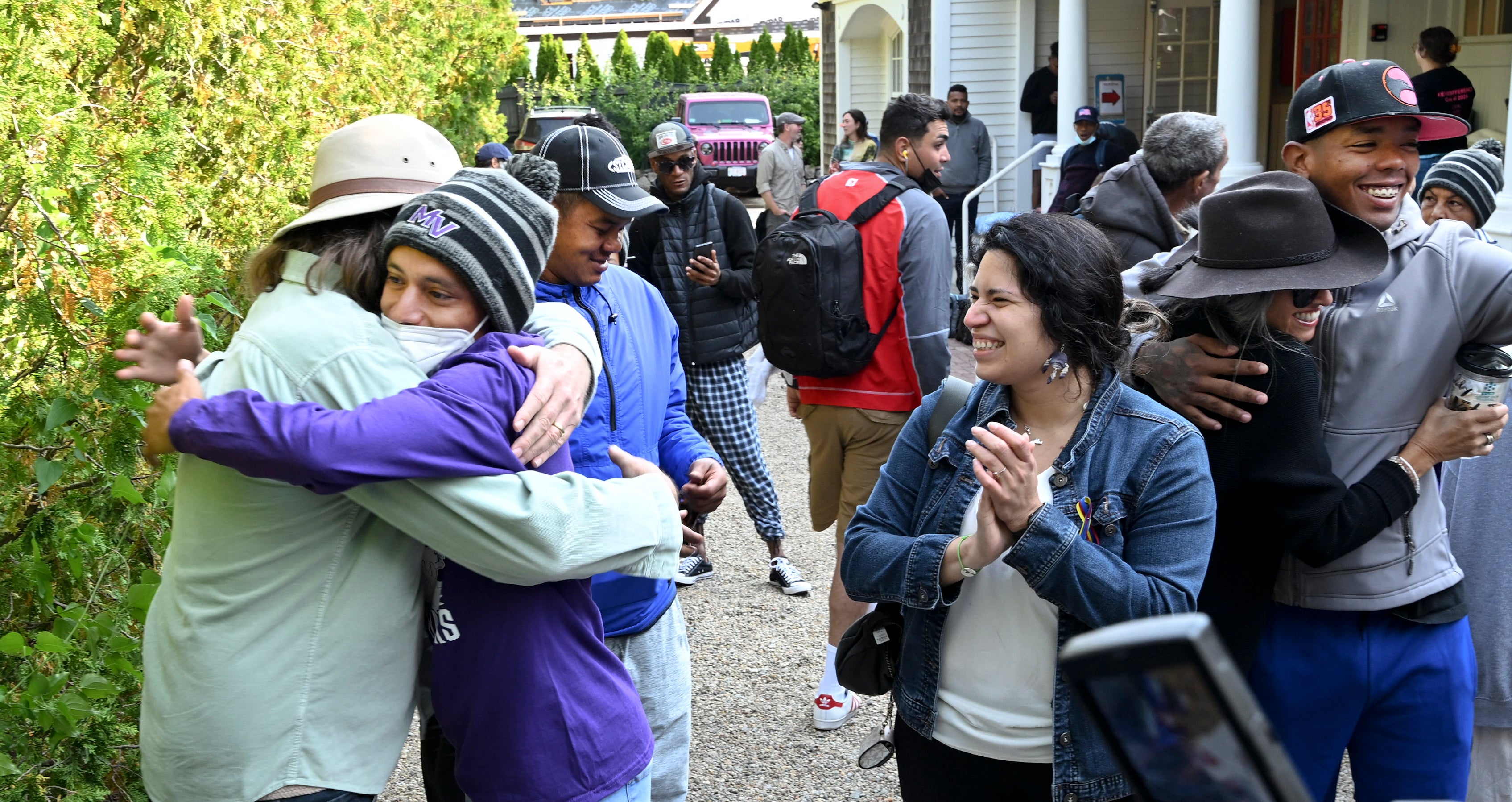 Carlos Munoz reaches out to hug Larkin Stallings as migrants prepare to leave St Andrews Church in Martha’s Vineyard on 16 September.