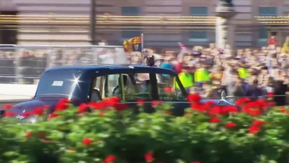 King Charles III greeted by cheering crowds as he arrives at Buckingham Palace