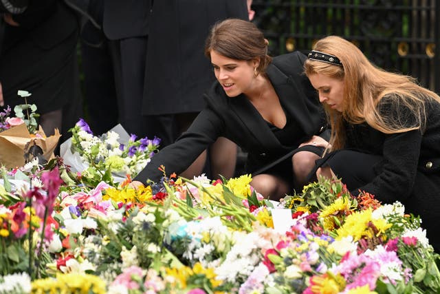 <p>Princess Eugenie and Princess Beatrice look at flowers left for the late monarch by the public outside the gates of Balmoral Castle</p>