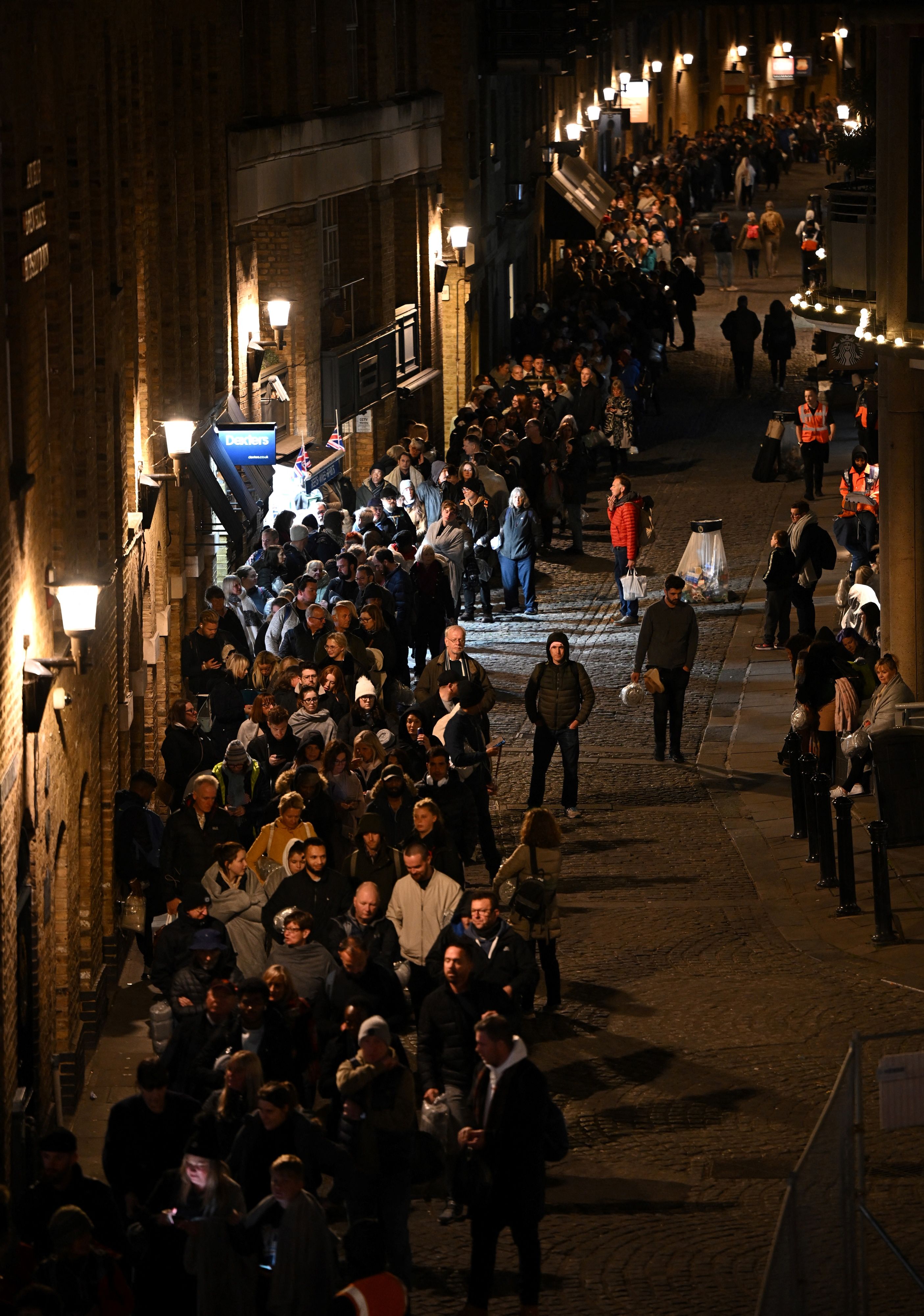 People stand in the queue in the early hours of the morning, near to Tower Bridge