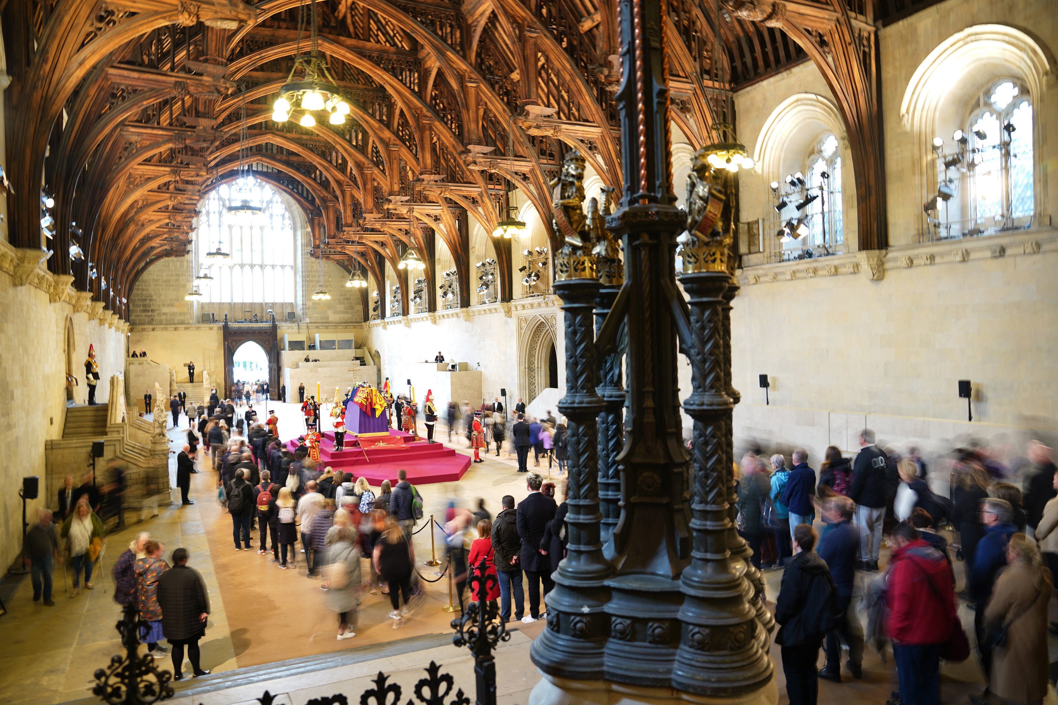 Members of the public file past the coffin of Queen Elizabeth II, draped in the Royal Standard with the Imperial State Crown and the Sovereign's orb and sceptre