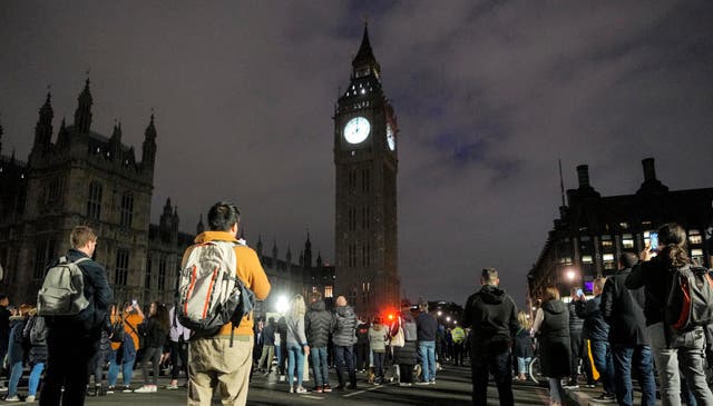 <p>People hold a minute of silence for the late Queen Elisabeth II at Westminster Bridge in front of Big Ben in London</p>