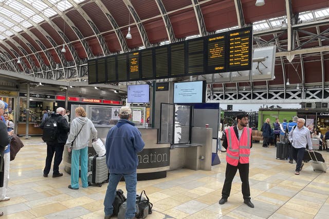 Members of the public look at the travel boards in Paddington Station, London, as all railway lines between Slough and Paddington are blocked due to damage to overhead electric wire (Margaret Davis/PA)
